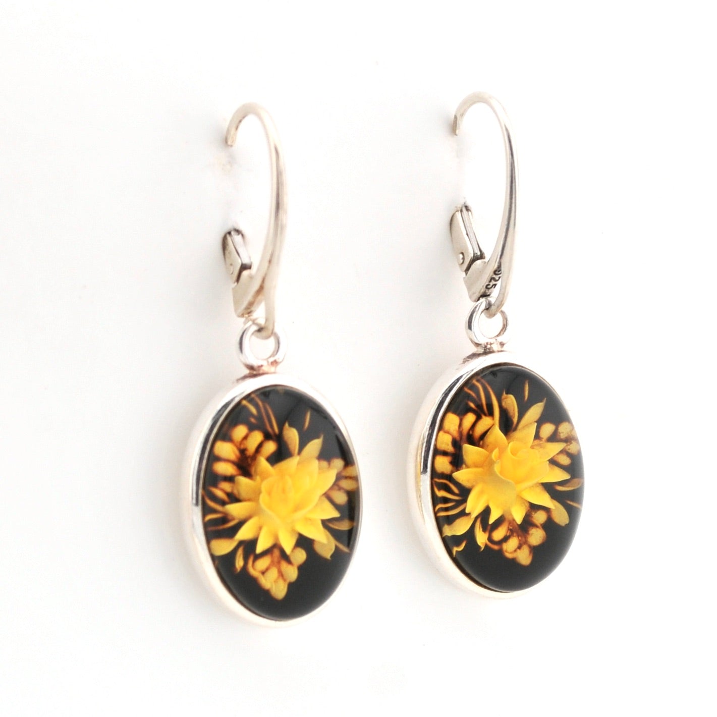 Pair of earrings with yellow floral design on black background