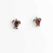 Pair of turtle-shaped earrings with amber stones on a white background
