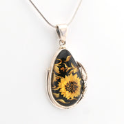 Silver pendant with a sunflower design on a white background