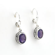 Silver earrings with purple gemstones on a white background