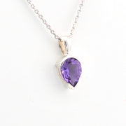 Purple teardrop pendant on a silver chain against a white background