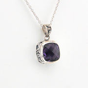 Silver pendant with a purple gemstone on a white background