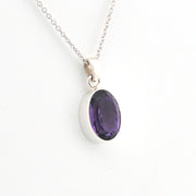 Silver necklace with a purple gemstone pendant on a white background
