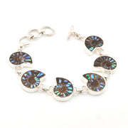 Silver bracelet with circular, multicolored stone components on a white background