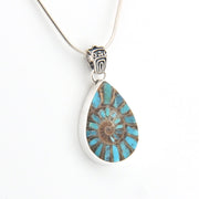 Teardrop-shaped pendant with blue and brown design on a white background