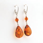 Pair of amber teardrop earrings on a white background