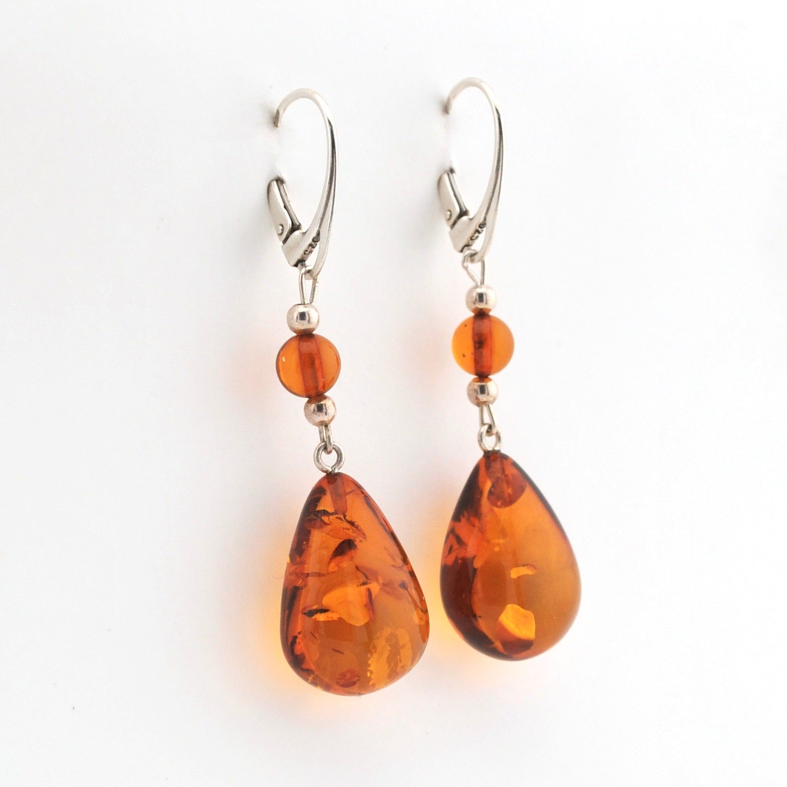 Pair of amber teardrop earrings on a white background