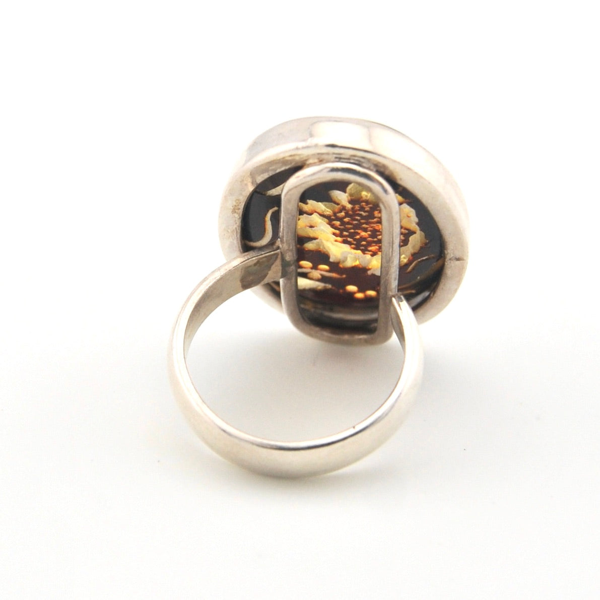 Silver ring with a sunflower design on a white background