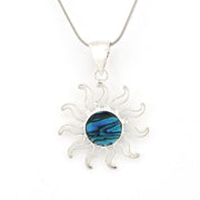 Silver sun-shaped pendant with a blue center on a white background