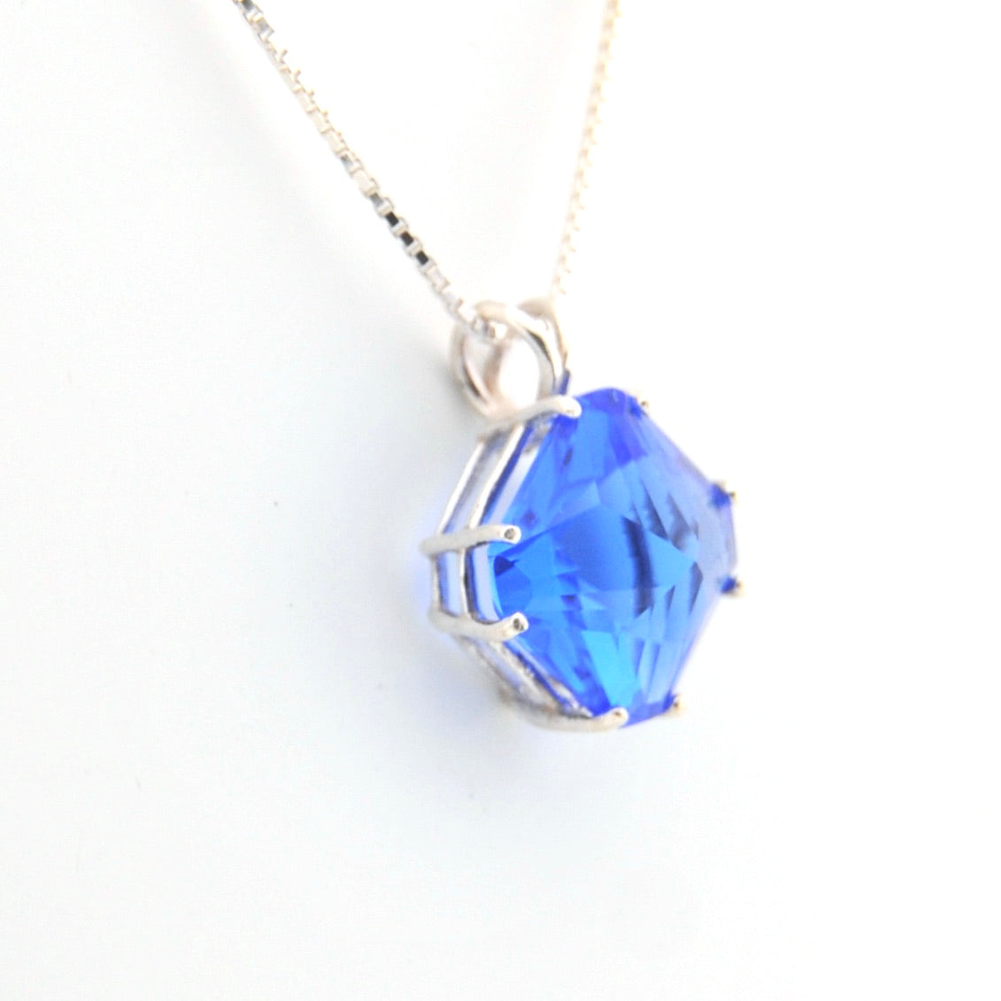 Blue crystal pendant on a white background