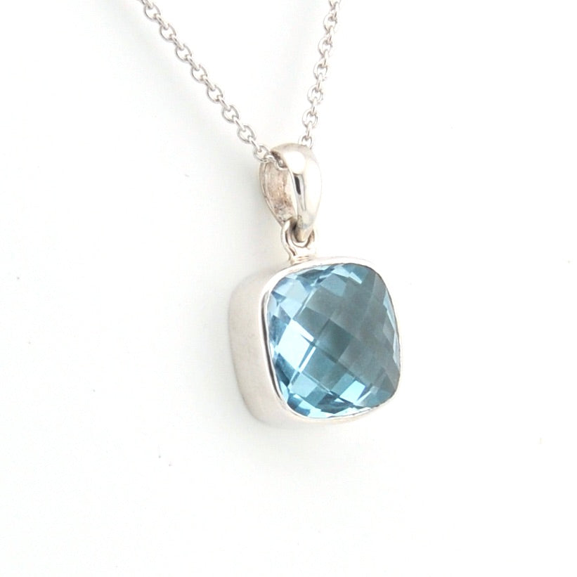 Silver pendant with a blue gemstone on a white background