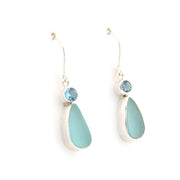 Pair of earrings with teardrop-shaped light blue stones on a white background