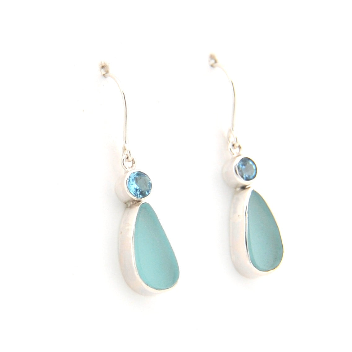 Pair of earrings with teardrop-shaped light blue stones on a white background