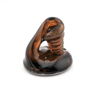 Glass sculpture with brown and black swirl pattern on a white background