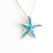Star-shaped pendant with blue opal inlay on a white background