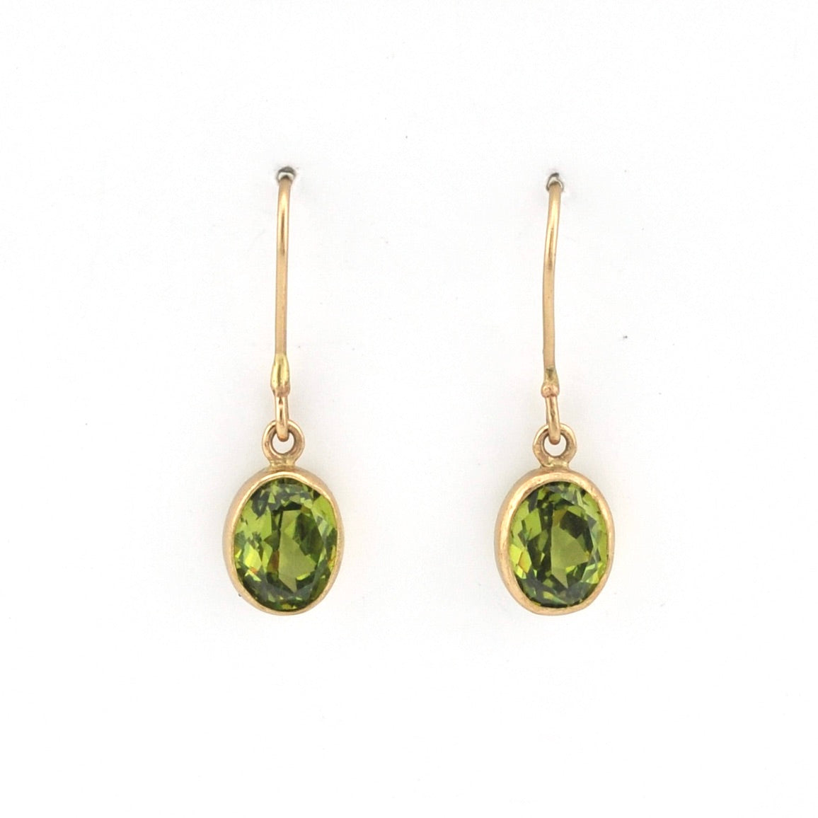 Gold earrings with green gemstones on a white background