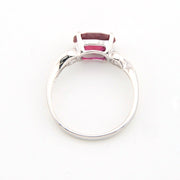 Silver ring with a red gemstone on a white background