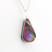 Multicolored teardrop pendant on a silver chain against a white background