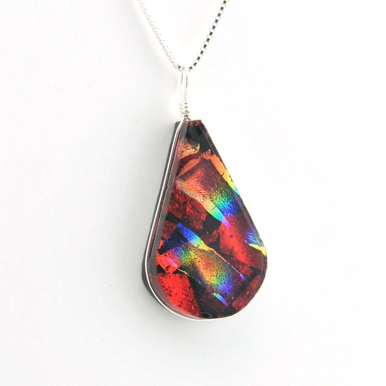 Teardrop-shaped pendant with multicolored pattern on a white background