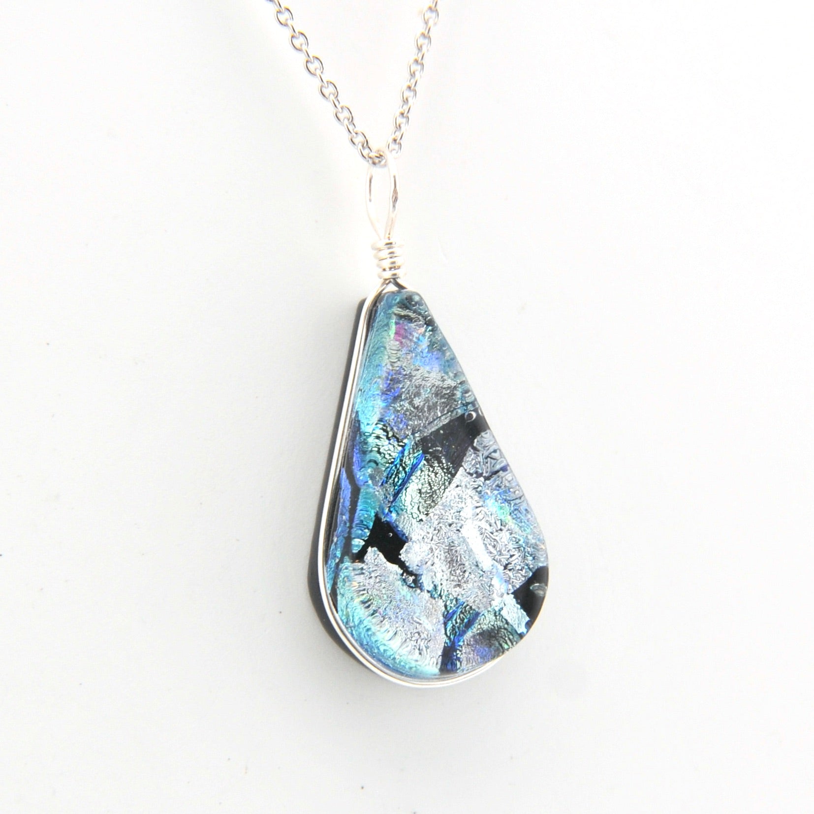 Teardrop-shaped pendant with a blue and silver design on a white background
