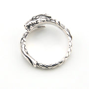 Silver ring with intricate design on a white background