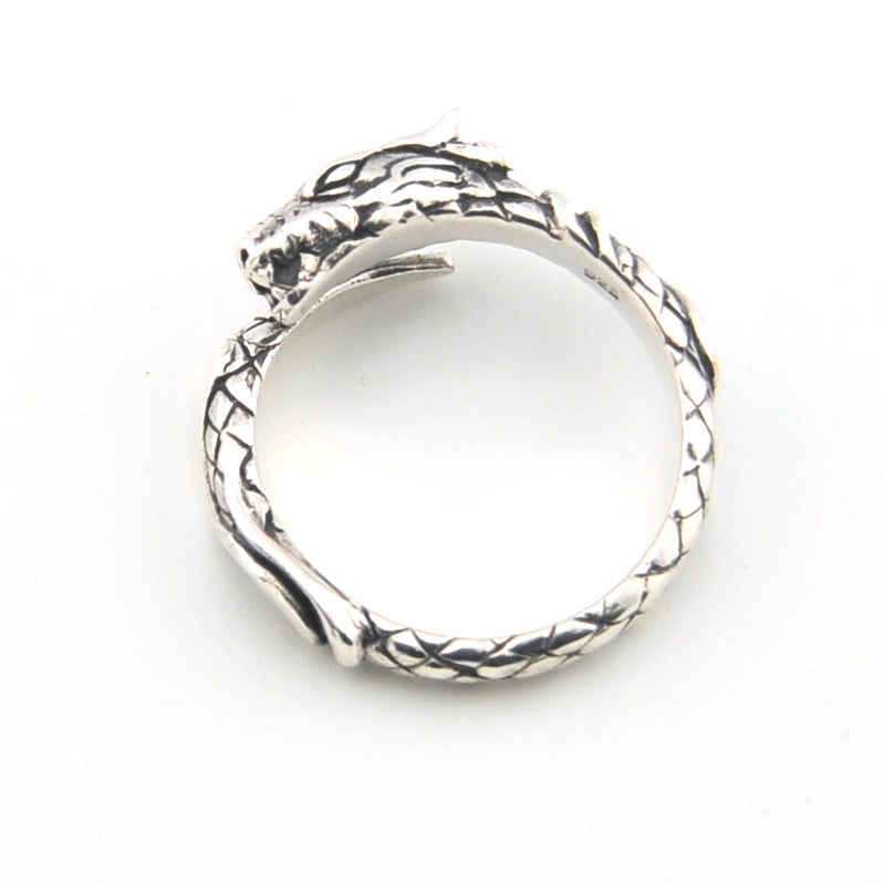 Silver ring with intricate design on a white background