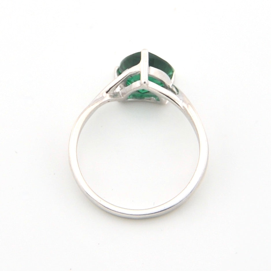 Silver ring with a green gemstone on a white background