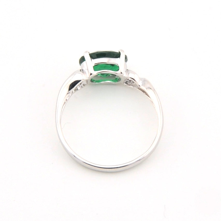 Silver ring with a green gemstone on a white background