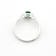 Silver ring with a green gemstone on a white background