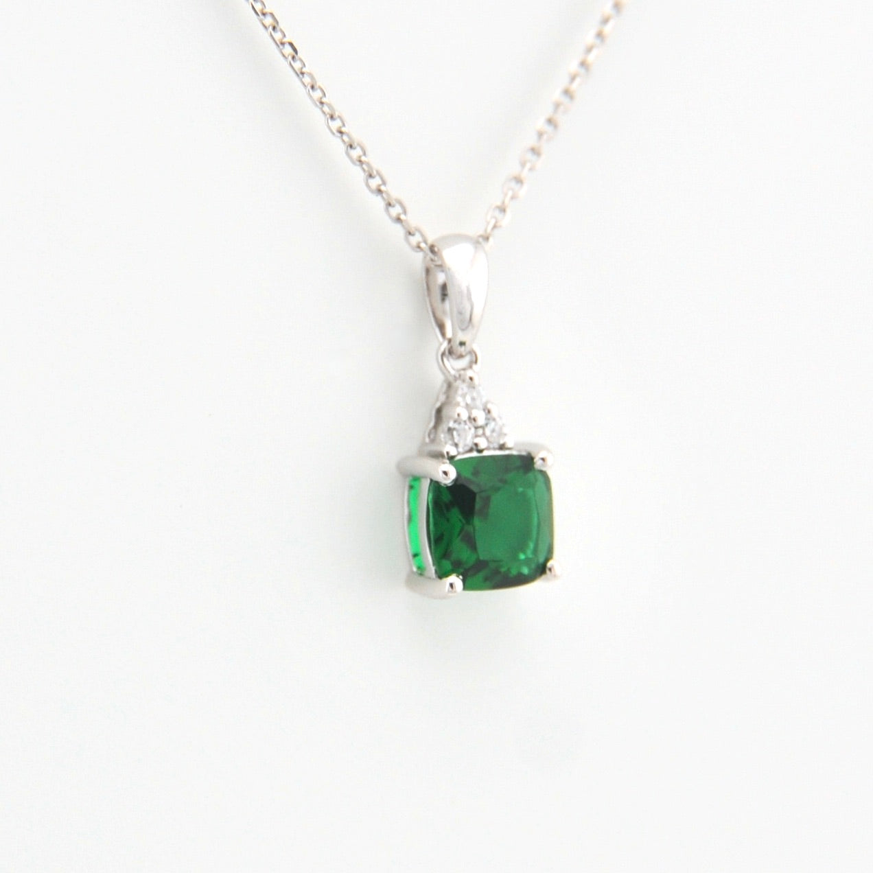 Green gemstone pendant on a white background