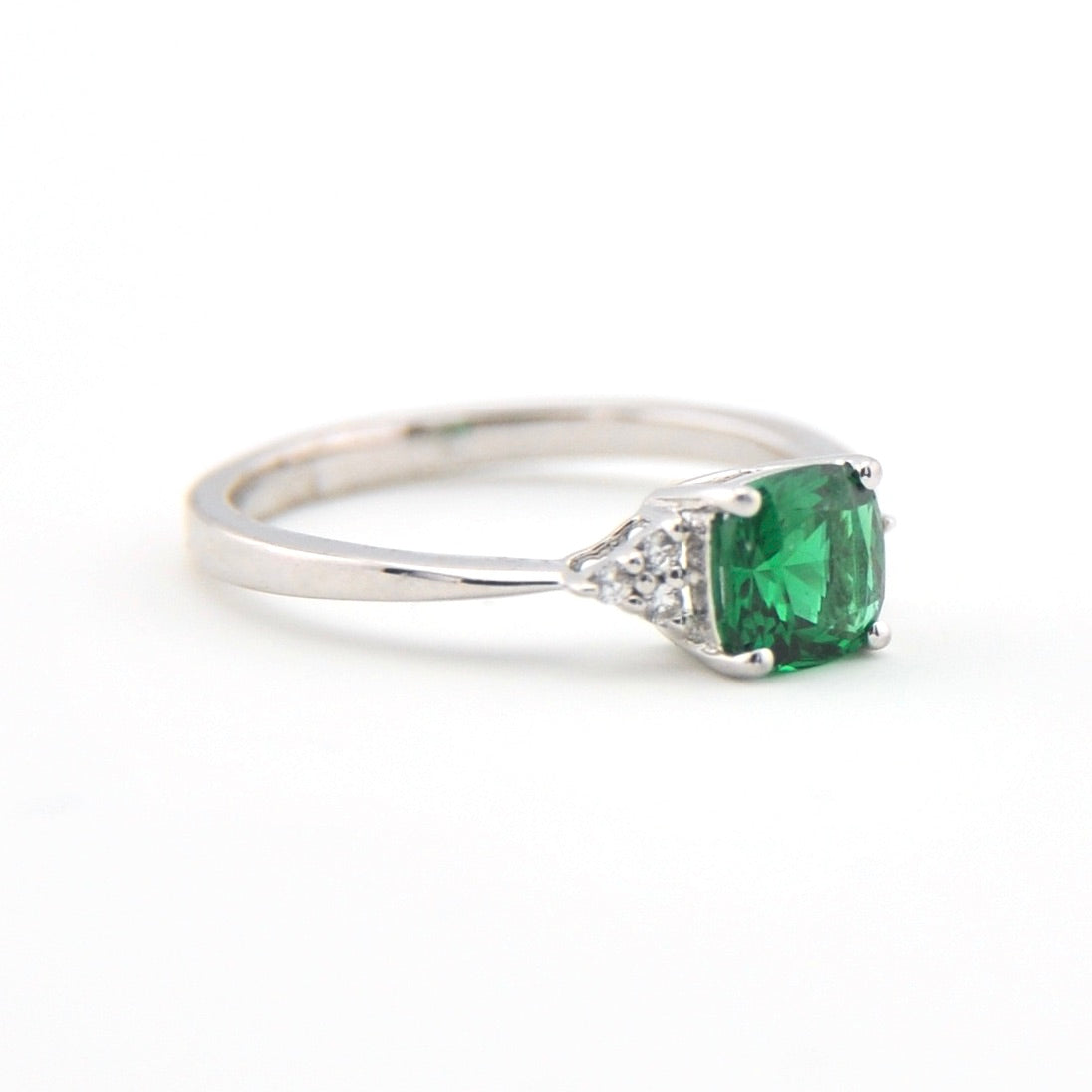 Silver ring with a green gemstone on a white background
