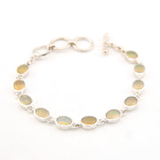 Silver bracelet with oval gemstones on a white background