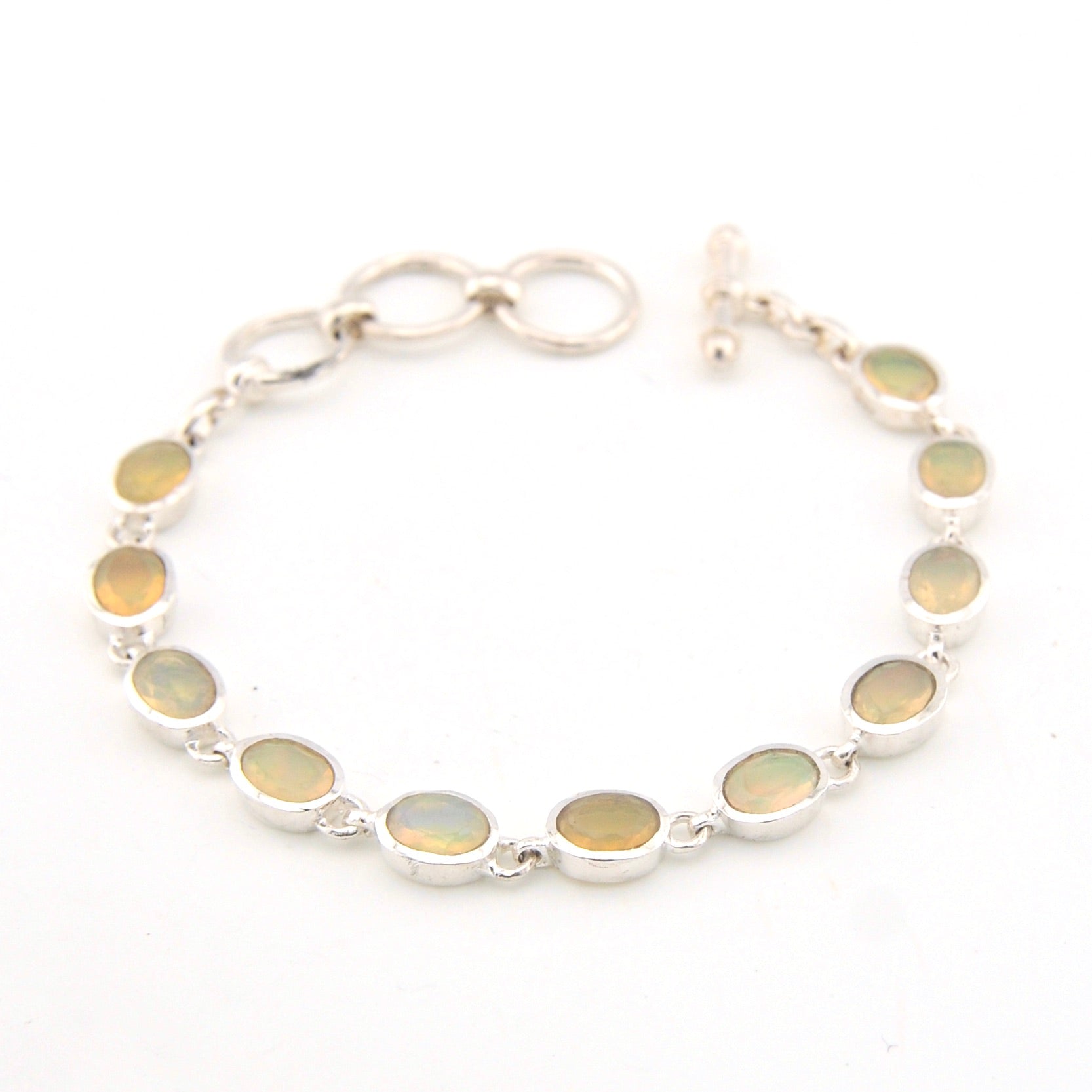 Silver bracelet with oval gemstones on a white background