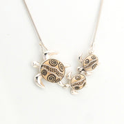 Silver turtle pendant necklace on a white background