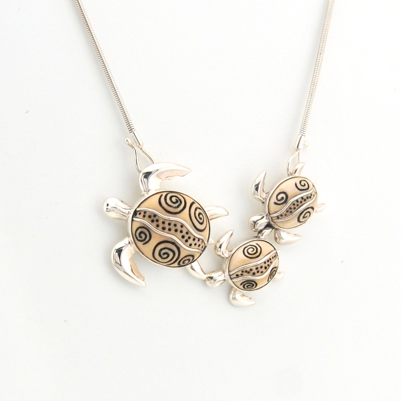 Silver turtle pendant necklace on a white background