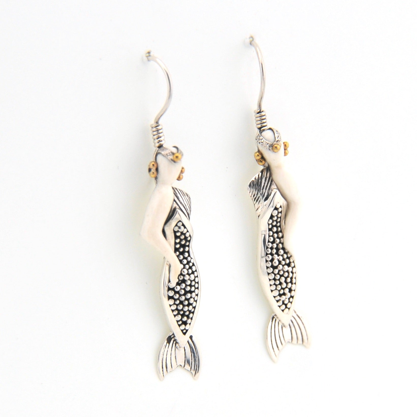 Silver mermaid earrings on a white background