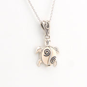 Silver turtle pendant necklace on a white background