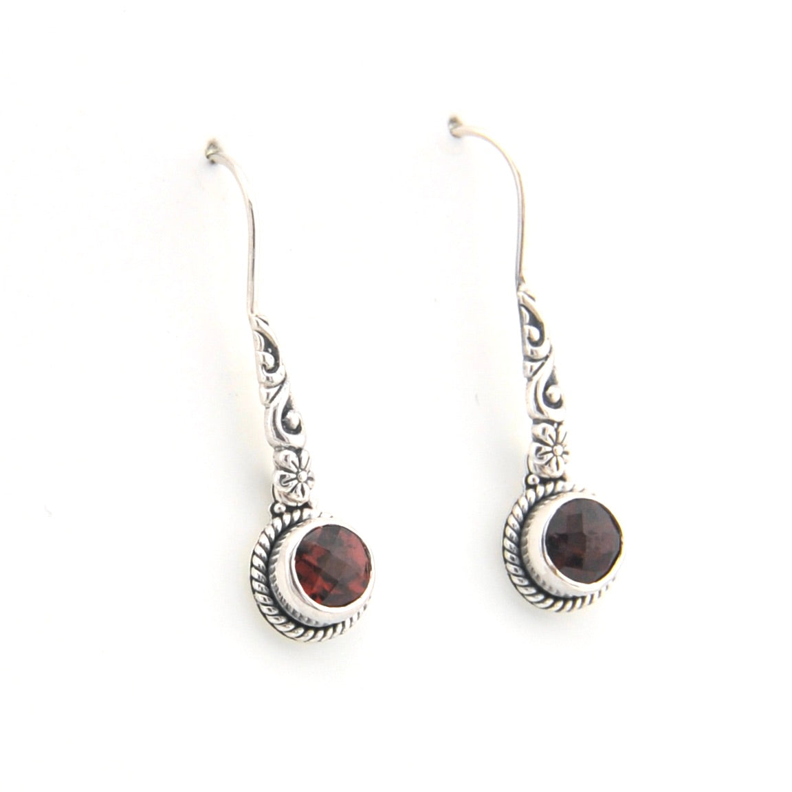 Pair of silver earrings with dark gemstones on a white background