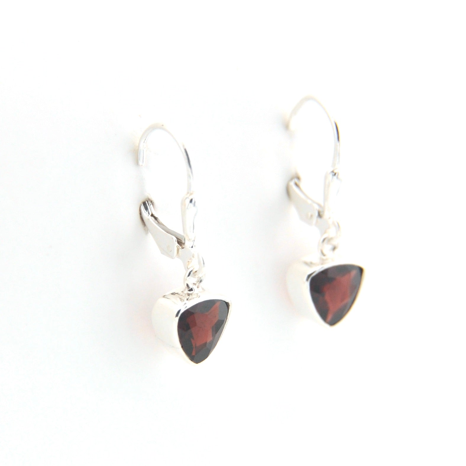 Pair of silver earrings with red gemstones on a white background