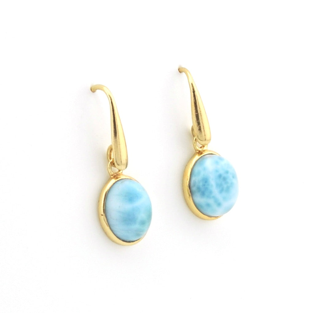 A pair of gold drop earrings featuring oval light blue marbled stone bezels, displayed on a clean white background.