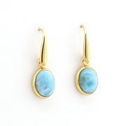 A pair of gold drop earrings with oval light blue marbled stone pendants, shown on a plain white background.