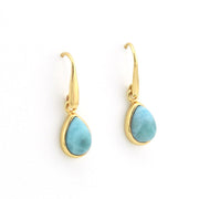 A pair of gold leverback drop earrings featuring teardrop-shaped light blue larimar stones, shown on a clean white background.