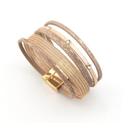 Set of gold mesh bracelets on a white background