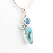 Hemimorphite pendant with blue topaz stones on a white background