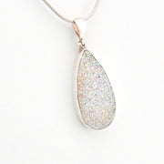 Teardrop-shaped silver pendant on a white background