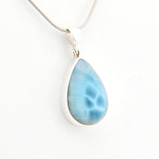 Teardrop-shaped blue pendant on a white background