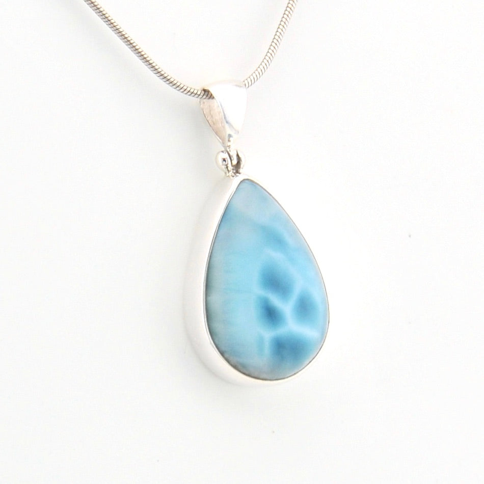 Teardrop-shaped blue pendant on a white background