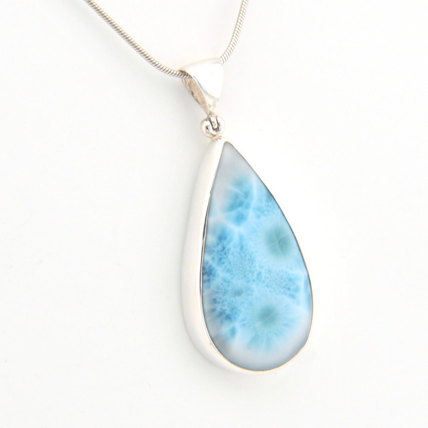 Teardrop-shaped larimar pendant on a white background