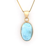 Gold necklace with a blue pendant on a white background