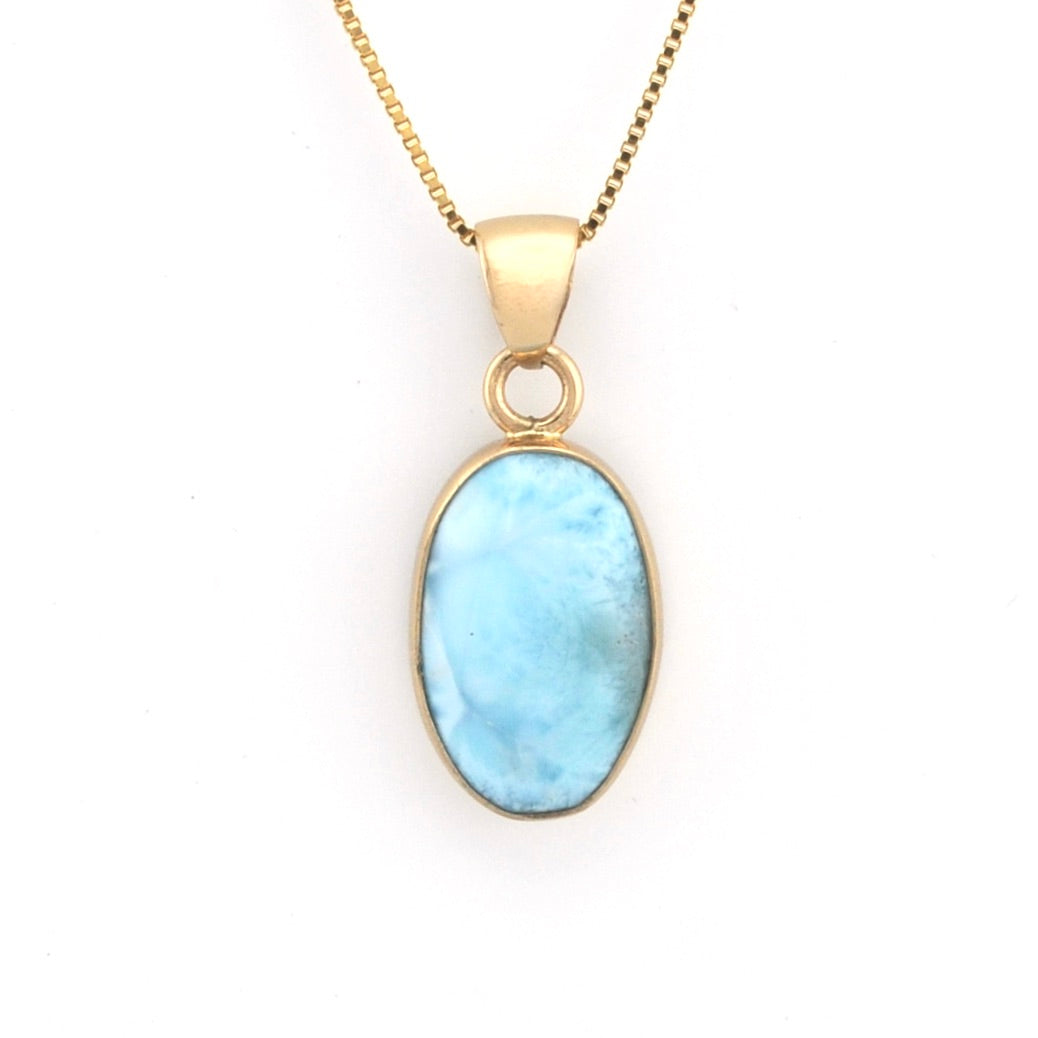 Gold necklace with a blue pendant on a white background